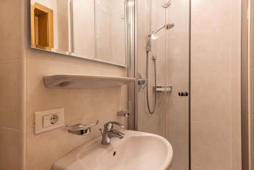 a bathroom with a sink and a shower at Unterhauserhof App B in Valdaora