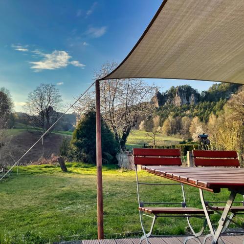 a picnic table and two benches in a field at Ferienhaus Gipfelblick im Sandsteinidyll in Rathen