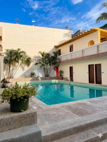 a swimming pool in front of a house at Hotel Skal Inn in Barranquilla