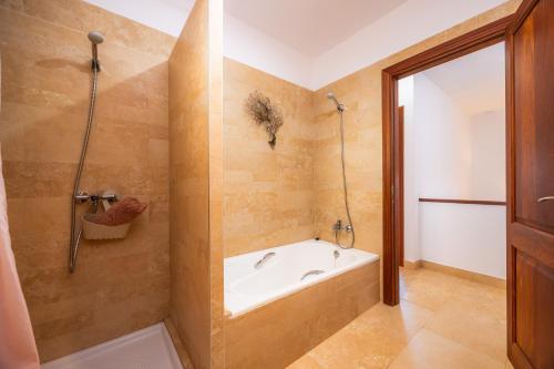 a bathroom with a tub and a shower at Oasis del Sol in Llombarts