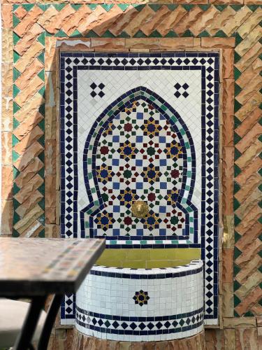 a mosaic tile wall with a fountain in a restaurant at Dar lalla Malika in Rabat