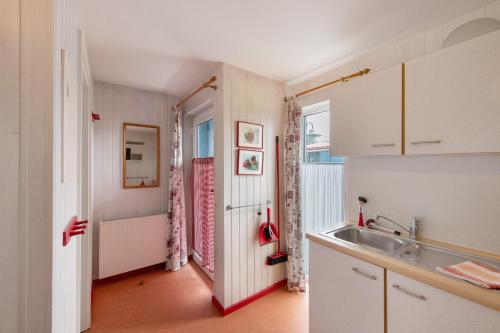 a small kitchen with a sink and a tub at Möve Aba Bungalow 67 in Rerik