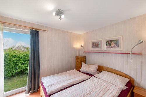 a bedroom with a bed and a large window at Möve Aba Bungalow 67 in Rerik