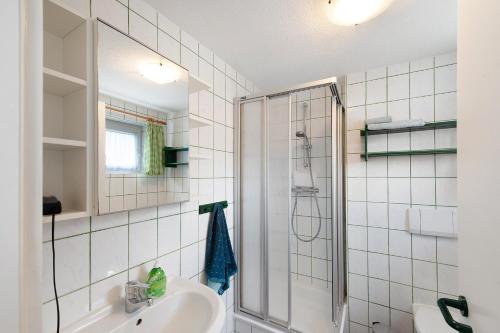 a white bathroom with a shower and a sink at Möve Aba Bungalow 64 in Rerik