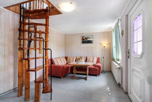 a living room with a red couch and a spiral staircase at Ferienhaus Pahnke in Bergen auf Rügen