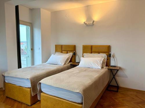 two beds sitting next to each other in a room at Old Town Heritage by Mrav in Sukošan