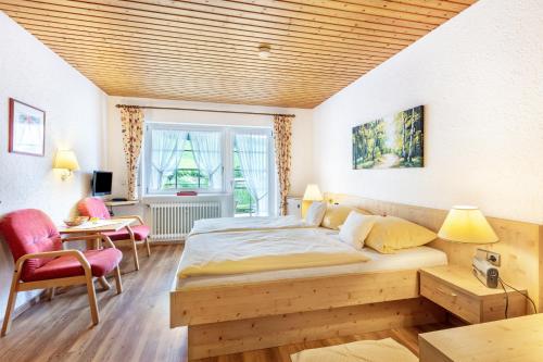 a bedroom with a bed and a table and chairs at Glöcklehof in Todtnau