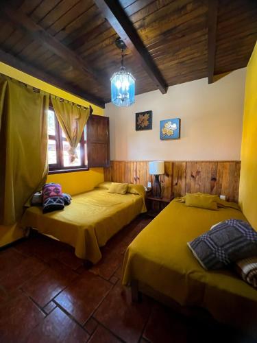 two beds in a room with wooden walls at Villas Lupita in Mazamitla