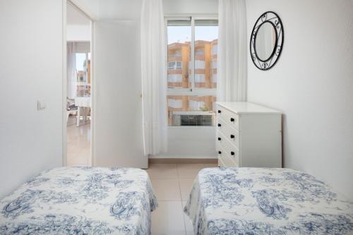 ein Schlafzimmer mit zwei Betten und einem Spiegel an der Wand in der Unterkunft Bloque 78 in Torrox