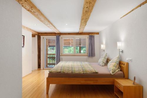 ein Schlafzimmer mit einem Bett und einem Fenster in der Unterkunft Müllerjörgenhof in Gutach
