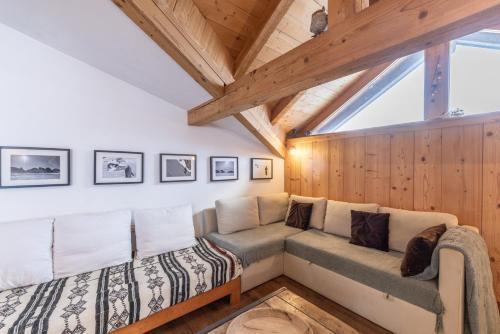 a living room with a couch and a window at Appartement style loft Chamonix in Les Houches