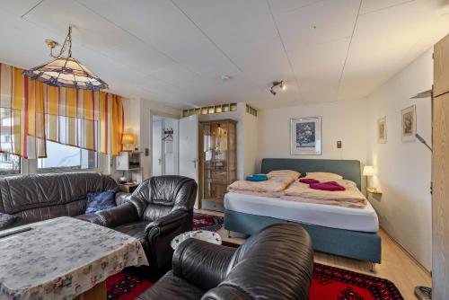 a bedroom with a bed and a living room at Ferienwohnung Behrens-Reinke in Albstadt