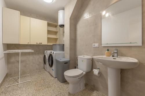 a bathroom with a white toilet and a sink at Edificio El Baifo Loco - Constantin in Gran Tarajal