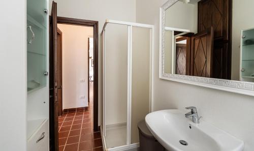 a bathroom with a sink and a mirror at Villa Aquila Giardino in Is Molas 