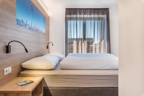 a bedroom with a bed and a window at Aster Moments Apt Marie in San Genesio Atesino