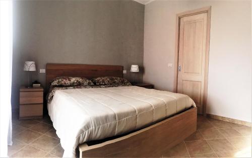 a bedroom with a bed with a wooden head board at Villa Florida 2 with private pool in San Teodoro