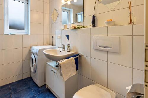 a bathroom with a washing machine and a sink at Ferienwohnung Im Holzhaus in Donaueschingen