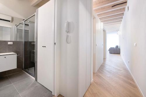 a bathroom with white walls and a walk in shower at Aa Imbarcadero apartments in Salò