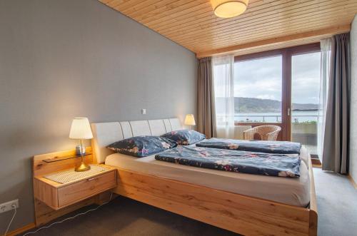 a bedroom with a bed and a large window at Merk Ferienwohnungen Gbr in Bodman-Ludwigshafen