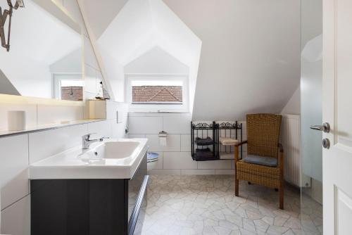 a bathroom with a sink and a chair at Sabines Ferienwohnung in Glückstadt