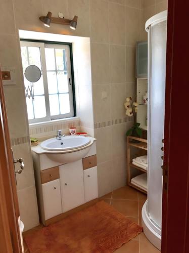 a bathroom with a sink and a window at Casa Sagres in Vila do Bispo