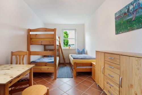 a bedroom with a bunk bed and a table and a desk at Haus Seeadler Wohnung 13 in Koserow