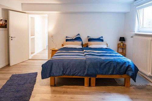 ein Schlafzimmer mit einem Bett mit blau-weißer Bettwäsche in der Unterkunft Seewest in Singen