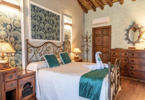 a bedroom with a bed with a swan on it at Casa Rural El Baluarte Habitaciones in Noves