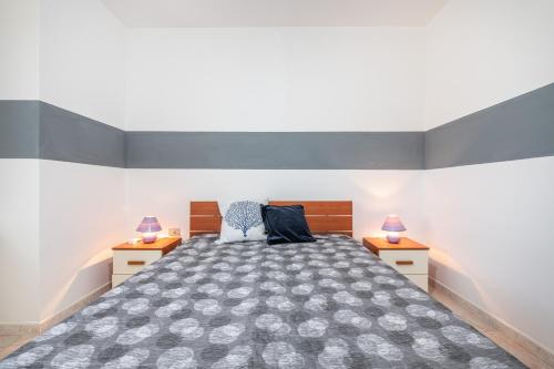 a bedroom with a large bed with two night stands at Casa Vacanza Casi 1 in Villasimius