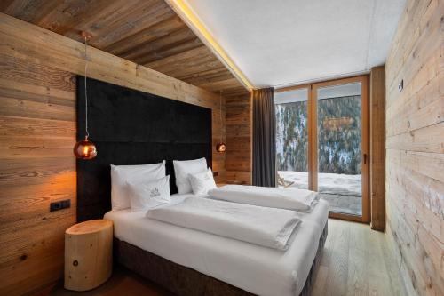 a bedroom with two beds and a large window at Chalet-Suite Wasser in Selva dei Molini