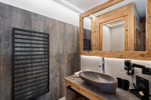 a bathroom with a stone sink and a mirror at Chalet-Suite Wasser in Selva dei Molini