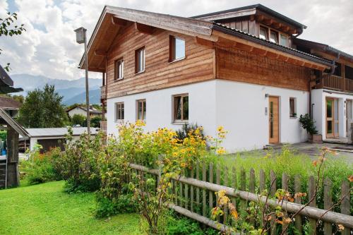 a house with a wooden roof and a fence at Chalet Falkenstein in Garmisch-Partenkirchen