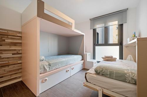 a small bedroom with a bunk bed and a window at Ap Calafell piscina, climatizado,pk in Calafell