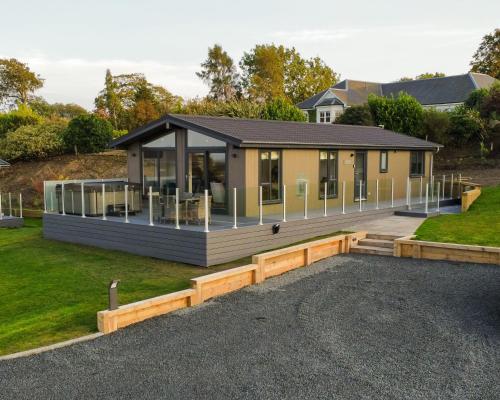 a house with a large deck in front of it at Drumcarrow Luxury Lodges in St. Andrews