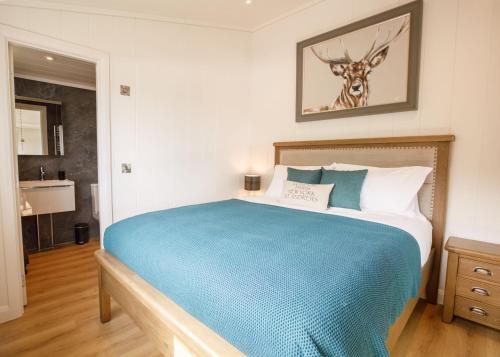 a bedroom with a large bed with a deer on the wall at Drumcarrow Luxury Lodges in St. Andrews