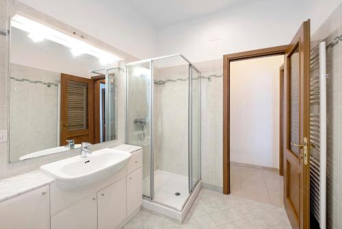 a white bathroom with a sink and a shower at Il Porto in Celle Ligure