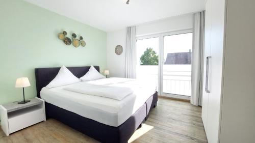 a bedroom with a bed and a large window at Dinkelbach Feriendomicil 2 D in Lindau-Bodolz