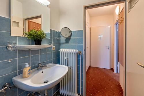 a bathroom with a sink and a mirror at Aparthotel am Stadtpark in Bad Sachsa
