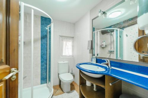 a bathroom with a blue sink and a toilet at Amontes Rural in Nestar