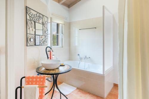 a bathroom with a sink and a bath tub at Casa Alecrim - Selão da Eira in Pedreneiras