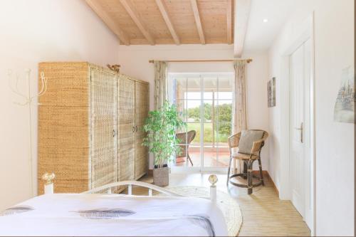 a bedroom with a bed and a table and chairs at Casa Alecrim - Selão da Eira in Pedreneiras