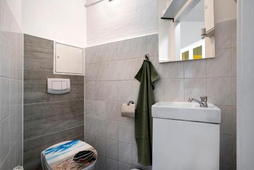 a bathroom with a toilet and a sink and a mirror at Ferienwohnung Chemnitz City in Chemnitz