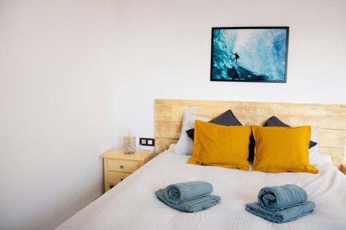 a bedroom with a bed with yellow and blue pillows at Casa Jenabe in La Vegueta