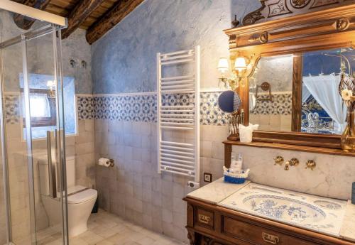 a bathroom with a toilet and a sink and a mirror at Casa Rural El Baluarte Habitaciones in Noves