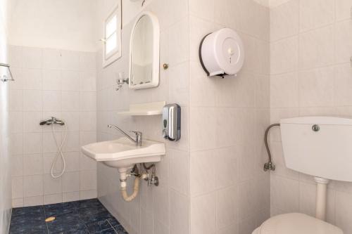 a bathroom with a sink and a toilet and a phone at Sifnos studio 5 in Sifnos