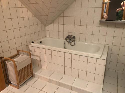 a bathroom with a bath tub in a tiled room at Moderne Vollmöblierte Wohnung in Zwickau
