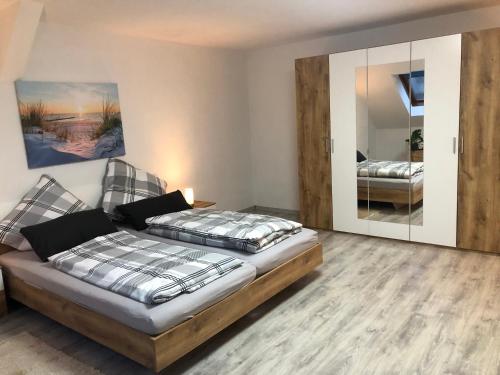 a bedroom with two beds and a mirror at Moderne Vollmöblierte Wohnung in Zwickau