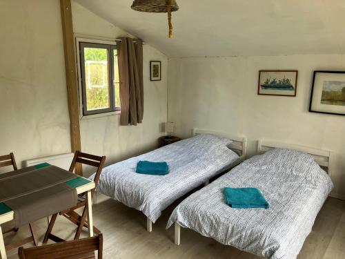 two beds in a small room with a table and a tableablish at Les Chalets de Babeth et Cathy in Trouan-le-Grand