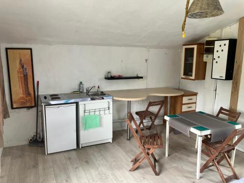 a kitchen with a table and a table and chairs at Les Chalets de Babeth et Cathy in Trouan-le-Grand
