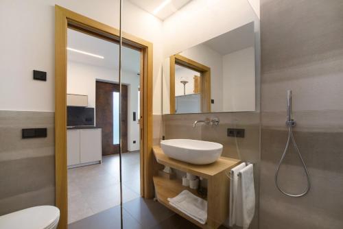 a bathroom with a sink and a toilet and a mirror at Haus Nummer 9 in Marlengo